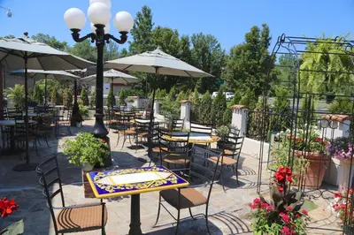an outdoor patio with tables and chairs and umbrellas at Best Western Plus Fairfield Executive Inn in Fairfield