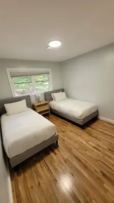 two beds in a room with wooden floors at Large Vacation Home Villa- Pool, Indoor Hotub, Game Room, up to 25 guests in Monticello