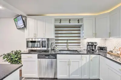 a kitchen with white cabinets and stainless steel appliances at Upscale Waterbury Retreat with Indoor Hot Tub! in Waterbury