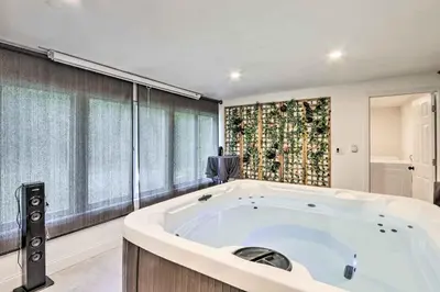 a large bath tub in a room with a window at Upscale Waterbury Retreat with Indoor Hot Tub! in Waterbury