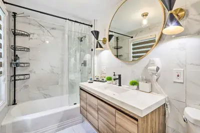a bathroom with a sink and a tub and a mirror at Upscale Waterbury Retreat with Indoor Hot Tub! in Waterbury