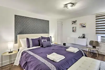 a bedroom with a large bed with purple sheets at Upscale Waterbury Retreat with Indoor Hot Tub! in Waterbury