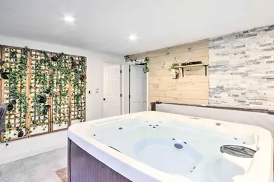 a large white tub in a room with a wall at Upscale Waterbury Retreat with Indoor Hot Tub! in Waterbury