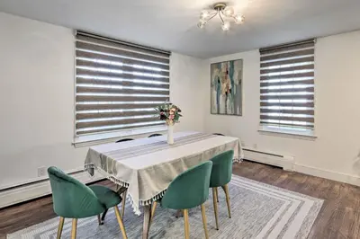 a dining room with a table and chairs and windows at Upscale Waterbury Retreat with Indoor Hot Tub! in Waterbury