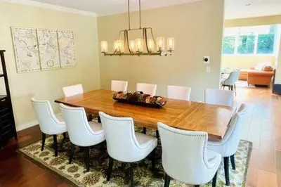 a dining room with a wooden table and white chairs at The Manor-Stunning Modern Farmhouse with Hot Tub in Dover