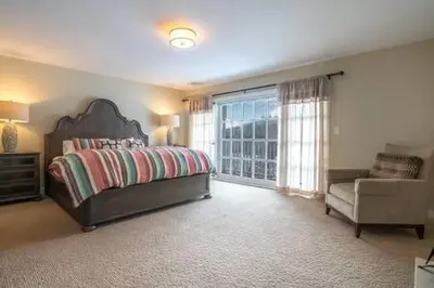 a bedroom with a bed and a chair and a window at The Manor-Stunning Modern Farmhouse with Hot Tub in Dover