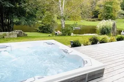 a large jacuzzi tub sitting on top of a deck at The Manor-Stunning Modern Farmhouse with Hot Tub in Dover