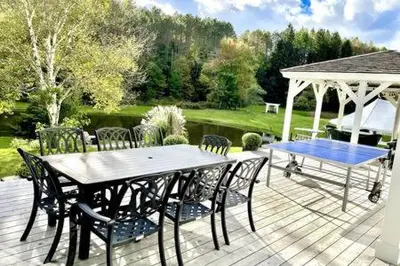 a table and chairs on a deck with a gazebo at The Manor-Stunning Modern Farmhouse with Hot Tub in Dover