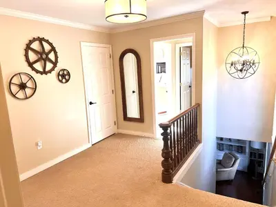 a hallway with a staircase and a mirror in a home at The Manor-Stunning Modern Farmhouse with Hot Tub in Dover