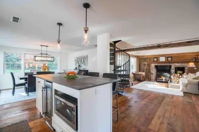 a large kitchen and living room with a fireplace at The Villa - Industrial Farmhouse with Hot Tub in Dover