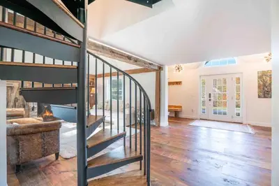 a living room with a spiral staircase in a house at The Villa - Industrial Farmhouse with Hot Tub in Dover