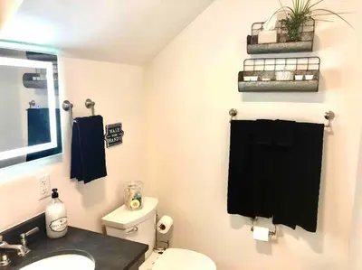 a bathroom with a toilet and a black towel at The Villa - Industrial Farmhouse with Hot Tub in Dover