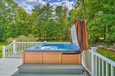a hot tub on a deck with an umbrella at Woodstock Getaway with Hot Tub about 2 Mi to Dtwn! in Woodstock