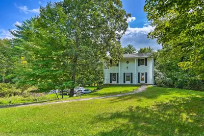 a white house with a tree in the yard at Woodstock Getaway with Hot Tub about 2 Mi to Dtwn! in Woodstock