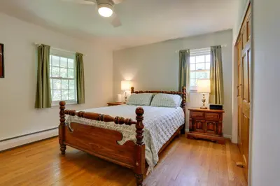 a bedroom with a bed and a wooden floor at Woodstock Getaway with Hot Tub about 2 Mi to Dtwn! in Woodstock