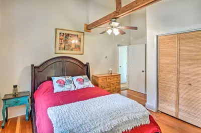 a bedroom with a red bed and a ceiling fan at Jewett Gem with Charcoal Grill and Mountain Views in Jewett