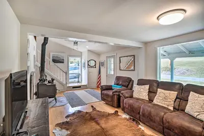a living room with a brown leather couch and a tv at Jewett Gem with Charcoal Grill and Mountain Views in Jewett