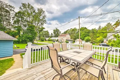 a wooden deck with a table and chairs on it at Cozy and Walkable Delmar Getaway with Fire Pit! in Delmar