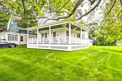 a large white house with a large yard at Cozy and Walkable Delmar Getaway with Fire Pit! in Delmar