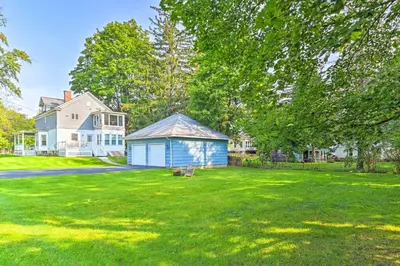 a large yard with a blue shed in front of a house at Cozy and Walkable Delmar Getaway with Fire Pit! in Delmar