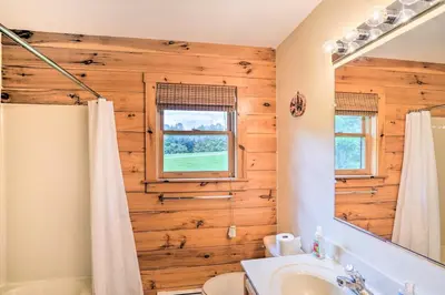 a bathroom with a wooden wall with a mirror at Grand Windham Retreat with Fire Pit and Game Room in Windham