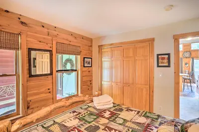 a bedroom with wooden walls and a bed and a window at Grand Windham Retreat with Fire Pit and Game Room in Windham