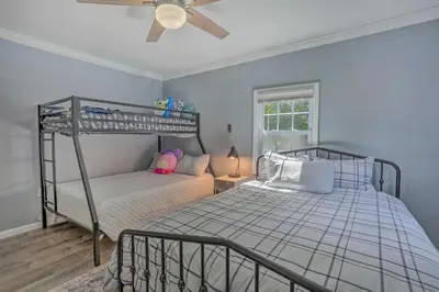 a bedroom with two bunk beds and a ceiling fan at Stunning South Fallsburg Home with Pool and Deck! in South Fallsburg