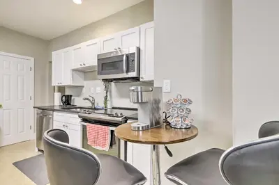 a kitchen with a table with chairs and a microwave at 2 Mi to Downtown Springfield Apt with Balcony! in Springfield