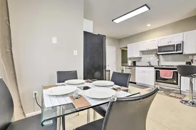 a dining room with a table and chairs and a kitchen at 2 Mi to Downtown Springfield Apt with Balcony! in Springfield