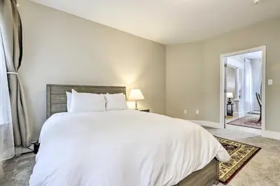 a bedroom with a large bed with white sheets at 2 Mi to Downtown Springfield Apt with Balcony! in Springfield