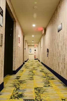 a hallway with a yellow and black tile floor at Super 8 by Wyndham Bronx Near Botanical Garden in Bronx