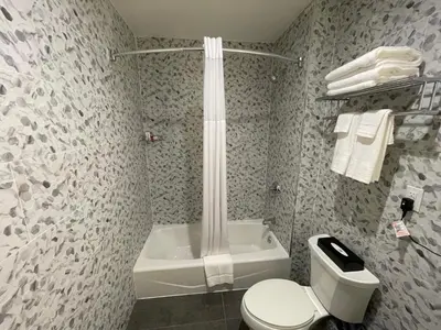 a bathroom with a shower and a toilet and a tub at Super 8 by Wyndham Bronx Near Botanical Garden in Bronx