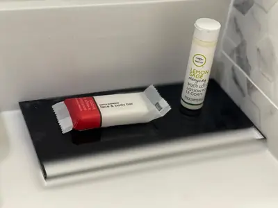 a shelf in a refrigerator with a bottle of sunscreen at Super 8 by Wyndham Bronx Near Botanical Garden in Bronx