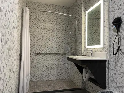 a bathroom with a shower and a sink at Super 8 by Wyndham Bronx Near Botanical Garden in Bronx