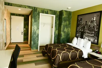 a hotel room with a bed and a table at Super 8 by Wyndham Bronx Near Botanical Garden in Bronx