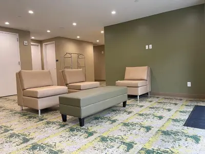 a waiting room with two chairs and a couch at Super 8 by Wyndham Bronx Near Botanical Garden in Bronx