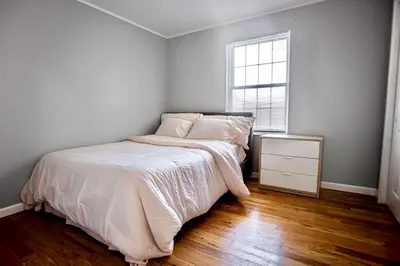 a white bedroom with a bed and a window at Urban Oasis Spacious 3BR 2BA Patio Near NYC EWR American Dream Mall in Newark