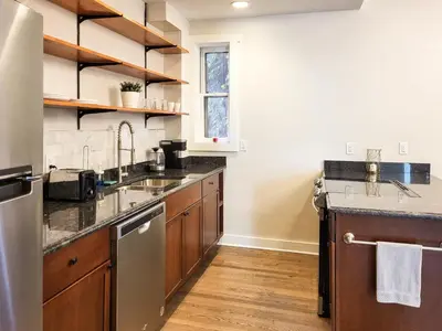 a kitchen with wooden cabinets and stainless steel appliances at Beautiful Wooster Sq. getaway - great neighborhood in New Haven