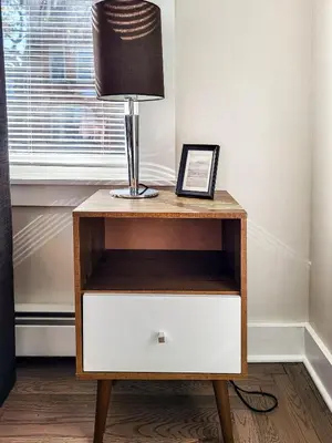 a nightstand with a lamp on top of it at Beautiful Wooster Sq. getaway - great neighborhood in New Haven