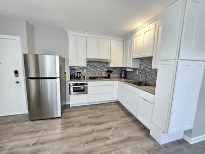 a kitchen with white cabinets and a stainless steel refrigerator at 1 Bedroom Apartment in Hartford