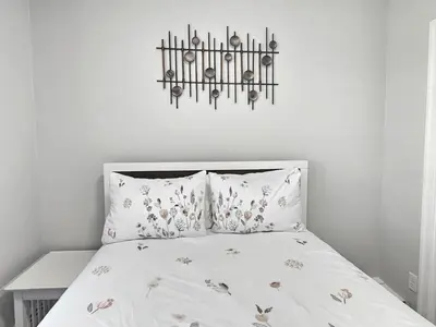 a bedroom with a white bed with flowers on it at 1 Bedroom Apartment in Hartford