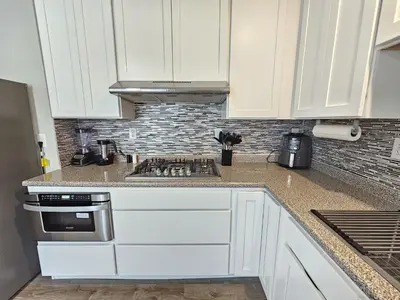 a kitchen with white cabinets and a stove top oven at 1 Bedroom Apartment in Hartford