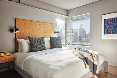 a bedroom with a large bed with a large window at Kasa Lantern Lower East Side in New York
