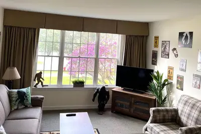a living room with a dog looking out a window at Unique Yeti-Theme Ski On Off Suite Jiminy-Sleeps 4 in Hancock