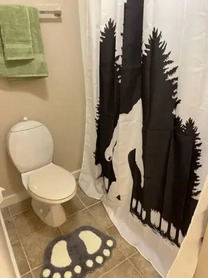a bathroom with a toilet and a black and white shower curtain at Unique Yeti-Theme Ski On Off Suite Jiminy-Sleeps 4 in Hancock