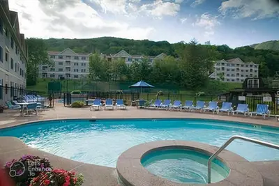 a large swimming pool with chairs and a hotel at Ski On Off 1BR Suite 1st Flr Sleeps 4 Jiminy Peak in Hancock