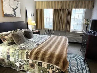 a bedroom with a bed with a blanket on it at Deluxe Ski On Off 1BR Suite Sleeps 4 on Jiminy Mtn in Hancock