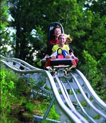 a woman and a child riding on a roller coaster at Deluxe Ski On Off 1BR Suite Sleeps 4 on Jiminy Mtn in Hancock