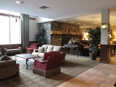 a living room with couches and a stone fireplace at Spacious 3BR 3BA Sleeps 8 Ski On Off Jiminy Mountain Resort in Hancock