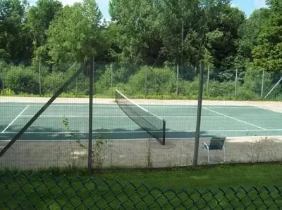 a tennis court with a net and a chair on it at Spacious 3BR 3BA Sleeps 8 Ski On Off Jiminy Mountain Resort in Hancock